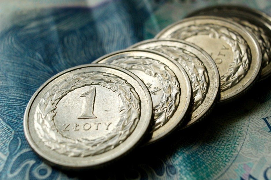 Zdjęcie ilustracyjne: monety 1 złotowe na tle banknotu o wartości 50 złotych